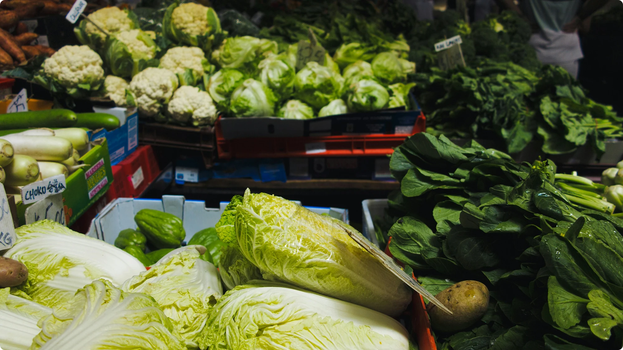 Puesto de mercado con coliflores y verduras